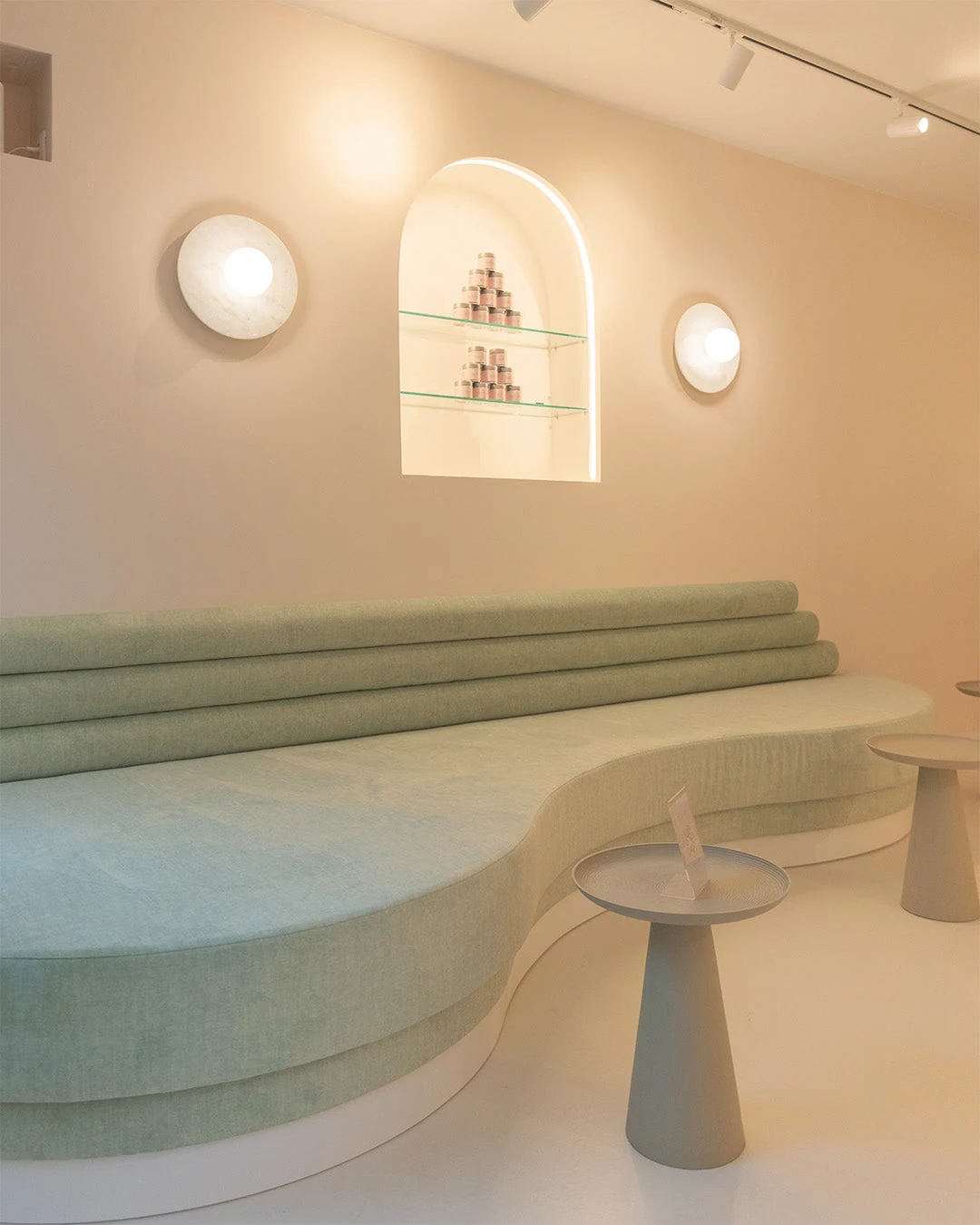 Curved green seating and small tables inside Gotcha Matcha