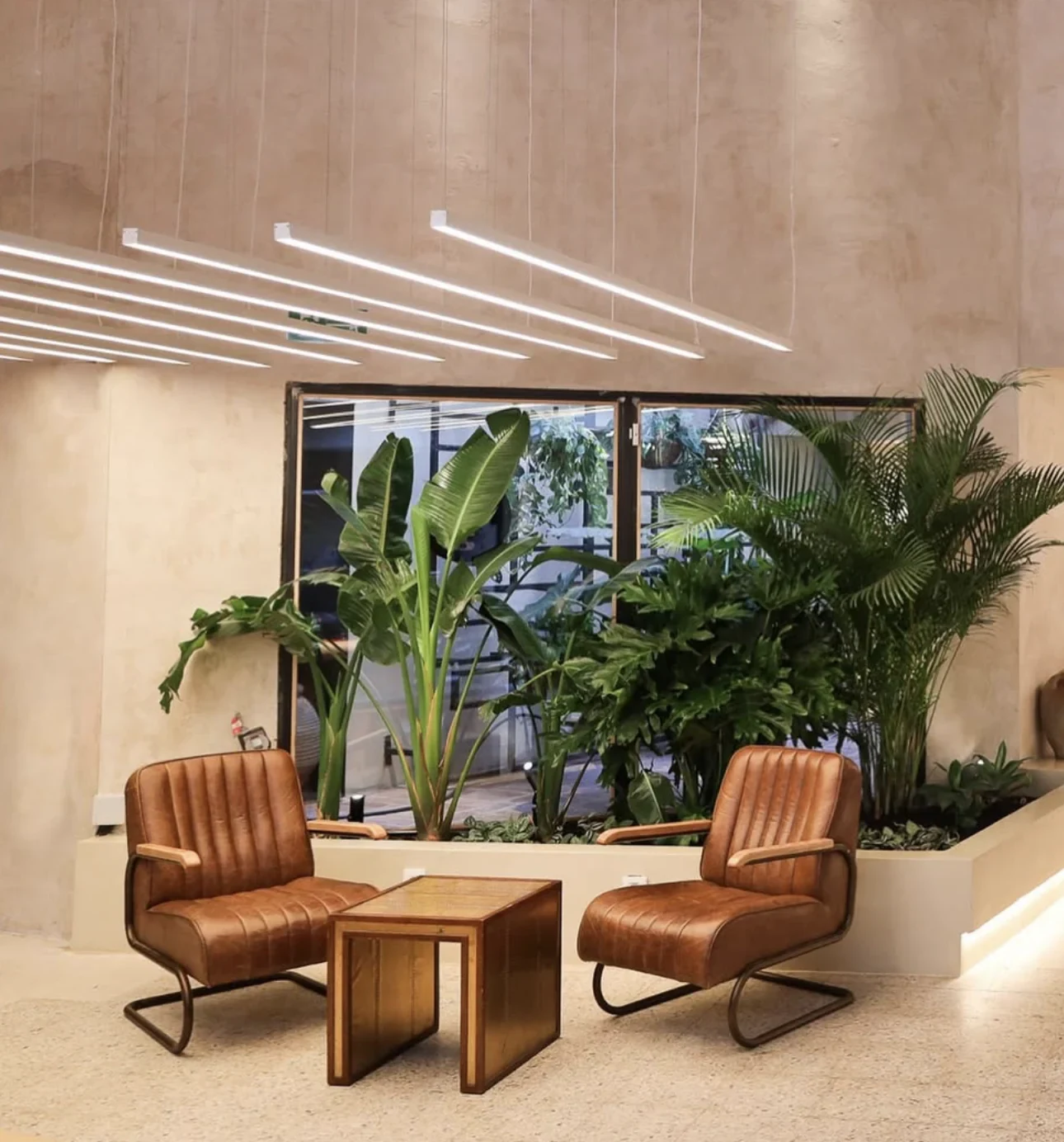 En Bruto — Leather chairs beside a large window